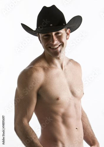 An attractive cowboy with his shirt off in studio