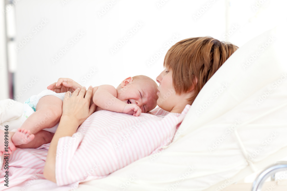 Woman kissing her newborn baby Woman kissing her newborn baby