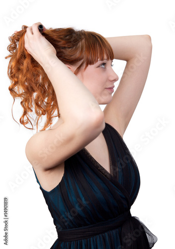 Young redhead woman straightening her hair