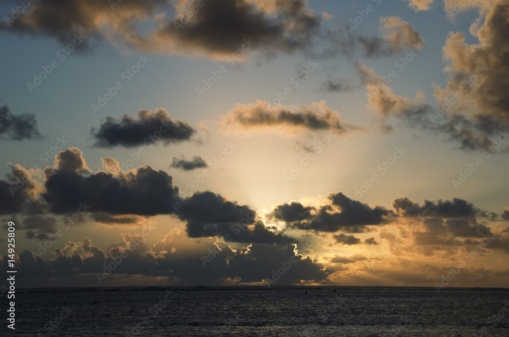 Sun setting behind dark Clouds over South Pacific Ocean