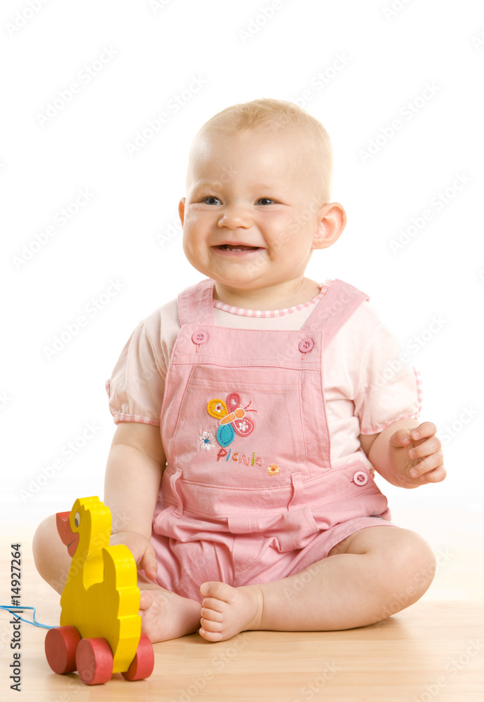 baby girl with a toy sitting on the floor baby girl with a toy sitting on the floor