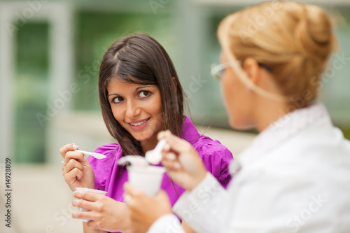 businesswomen eating yogurt