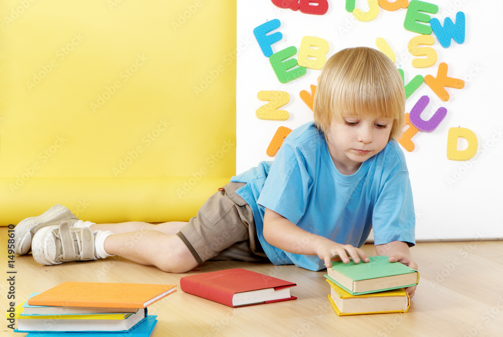 The little boy with books in a kindergarten. The little boy with books in a kindergarten.