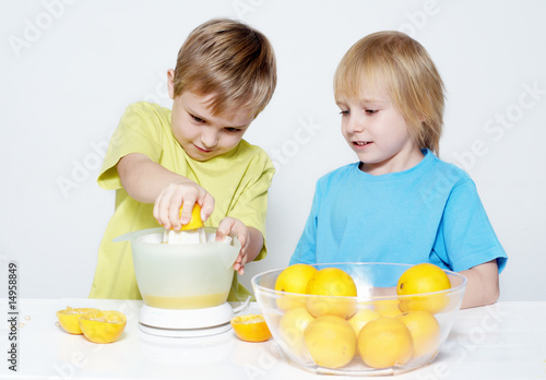 Children squeeze out orange juice