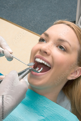 tooth extraction from Caucasian woman by dentist using Forceps