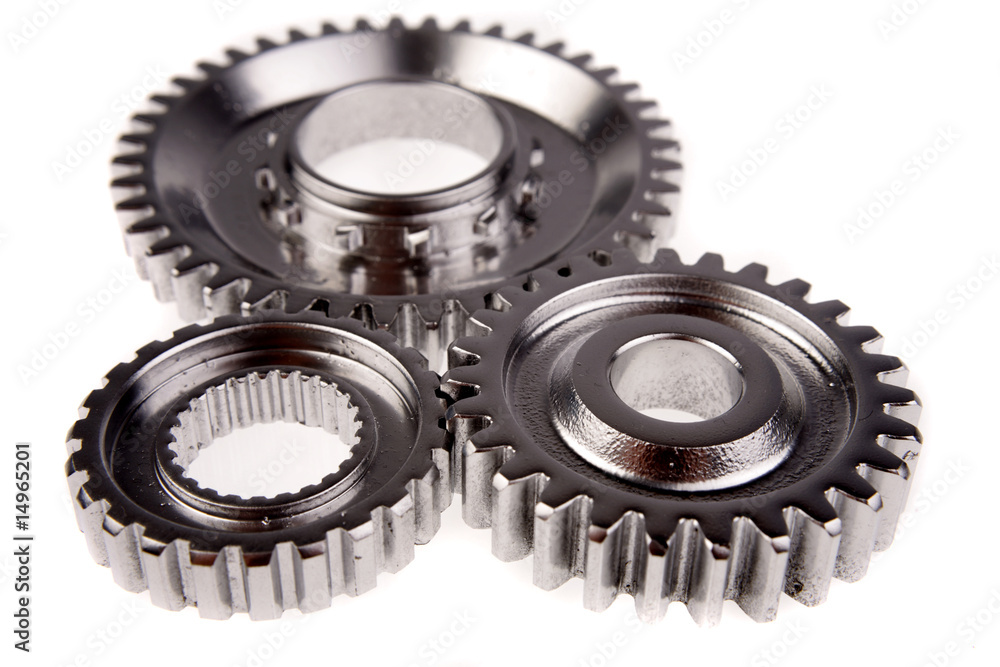 Three steel cog gears meshing together over white Three steel cog gears meshing together over white