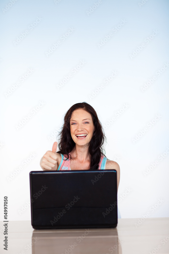Woman using her laptop with thumbs up and copy-space Woman using her laptop with thumbs up and copy-space