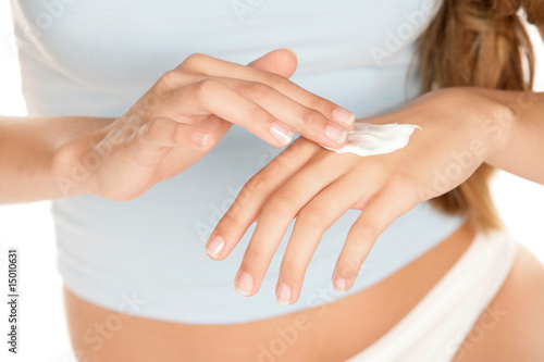 Young woman applying hand cream photo