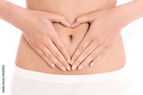 Woman forming heart shape on belly