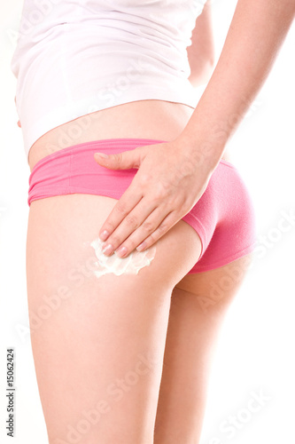 Woman applying moisturizer cream on legs
