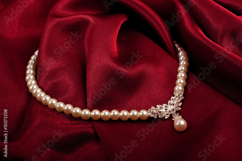 Pearl necklace on red textile