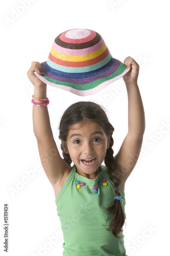 Little girl holding her hat above her head photo