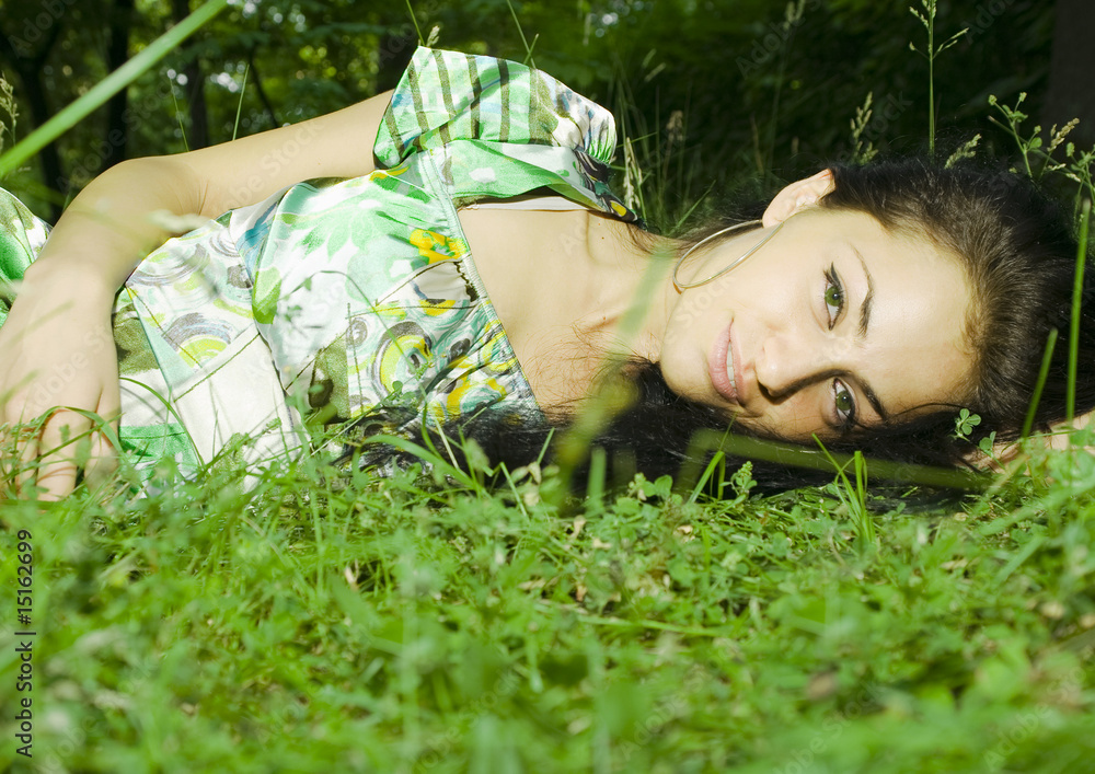 beautiful green eyed girl laying on the grass beautiful green eyed girl laying on the grass