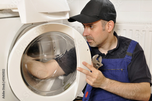 Handwerker repariert Waschmaschine photo