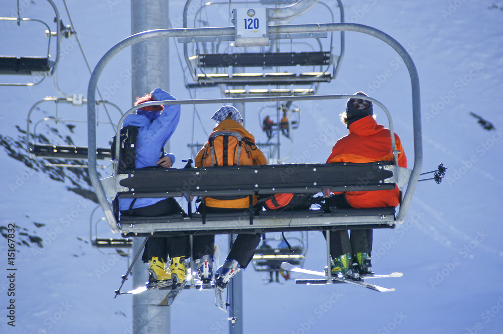 drei Skifahrer im Sessellift