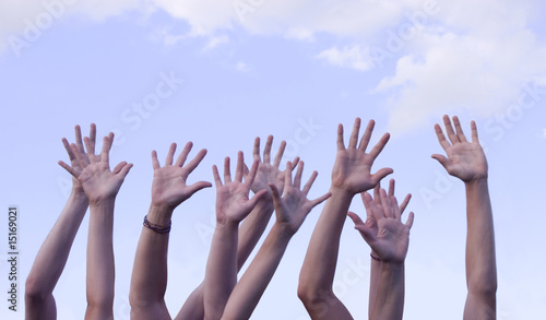 Hands Raised in Air Against Sky