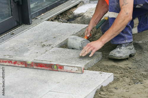 ouvrier en train de poser une dalle
