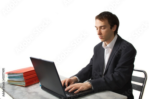 Young man works on laptop, side view