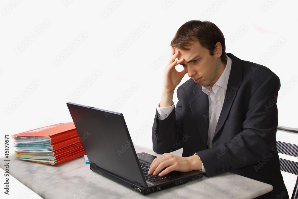 Young man works on laptop, worried