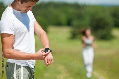 Young man with stopwatch measuring time
