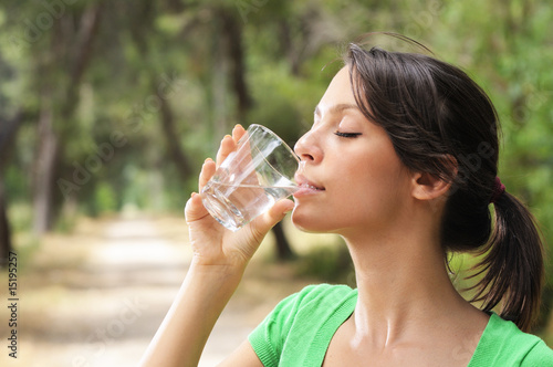 young woman water drinking in glass