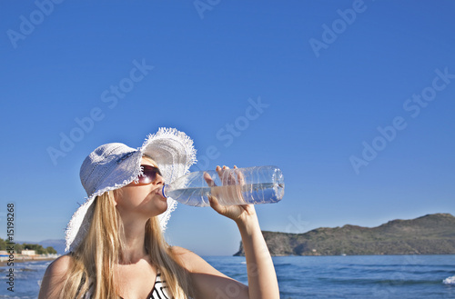 Young blond woman drinks water