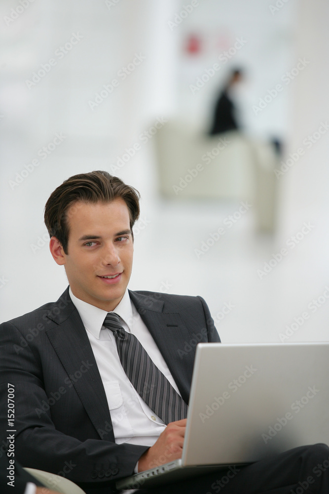 Jeune homme en costume devant un ordinateur portable Jeune homme en costume devant un ordinateur portable