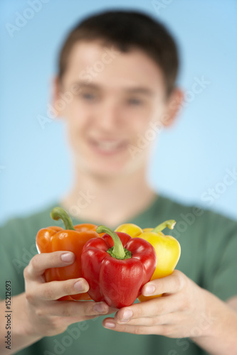 Teenage Boy Holding Fresh Peppers