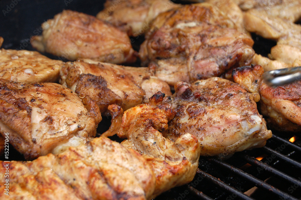 Chicken roasting on grill with fire