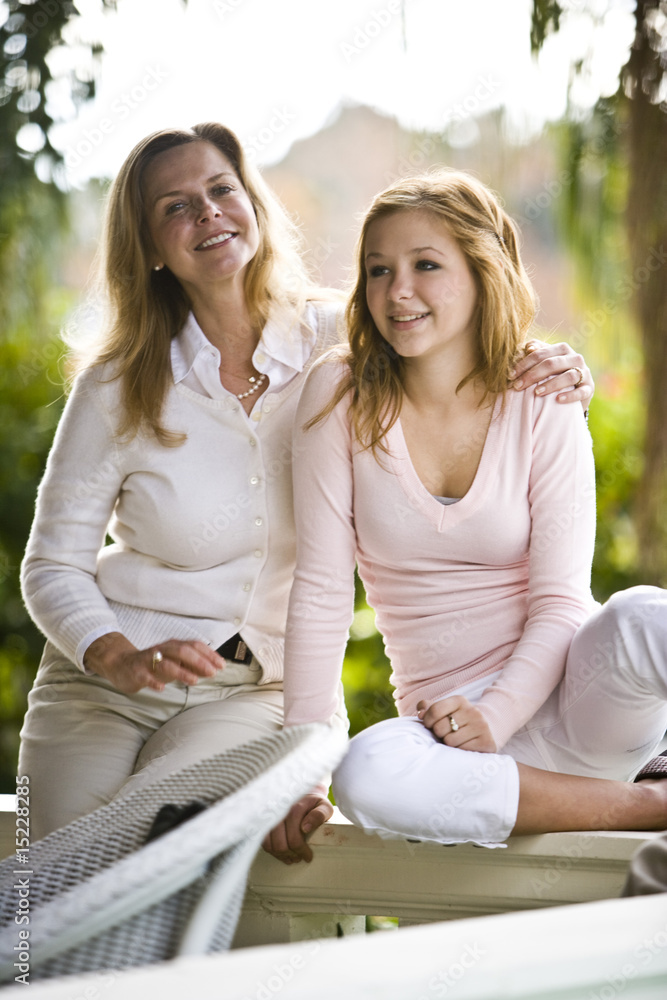Portrait of mother and daughter relaxing outdoors on terrace
