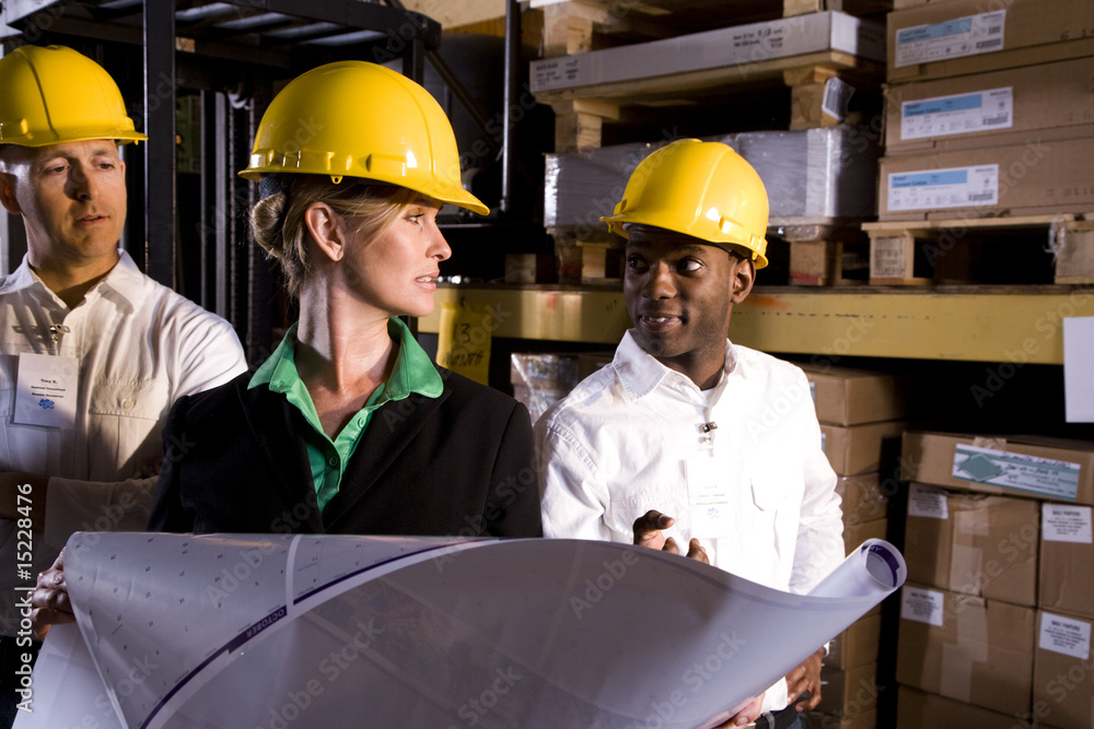 Workers with female boss in storage warehouse Workers with female boss in storage warehouse