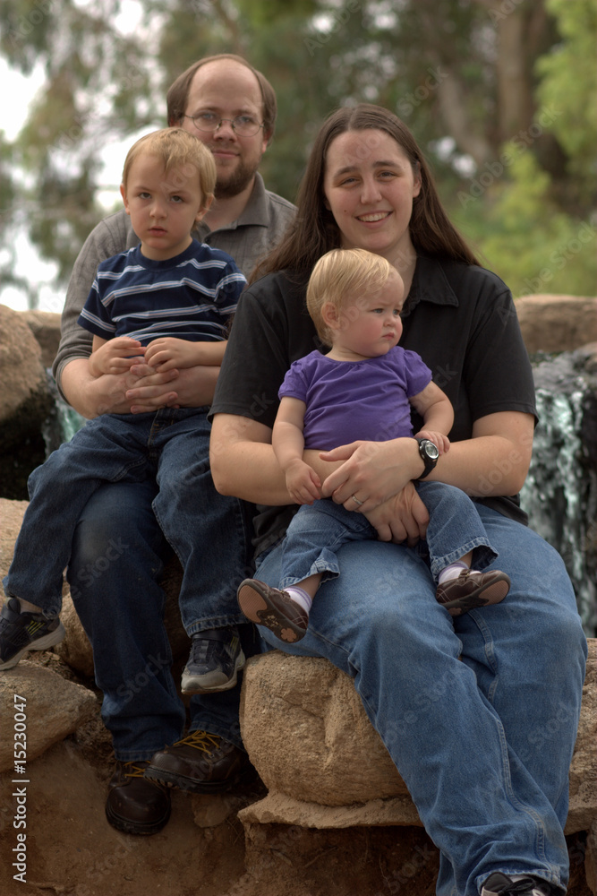 Family of 4 sitting on rocks
