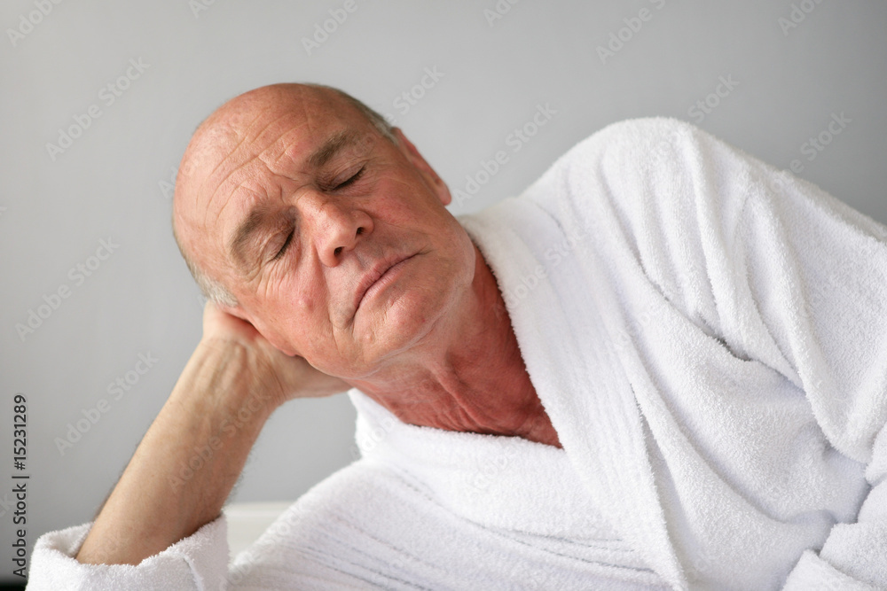 Portrait d'un homme senior en peignoir fermant les yeux Portrait d'un homme senior en peignoir fermant les yeux