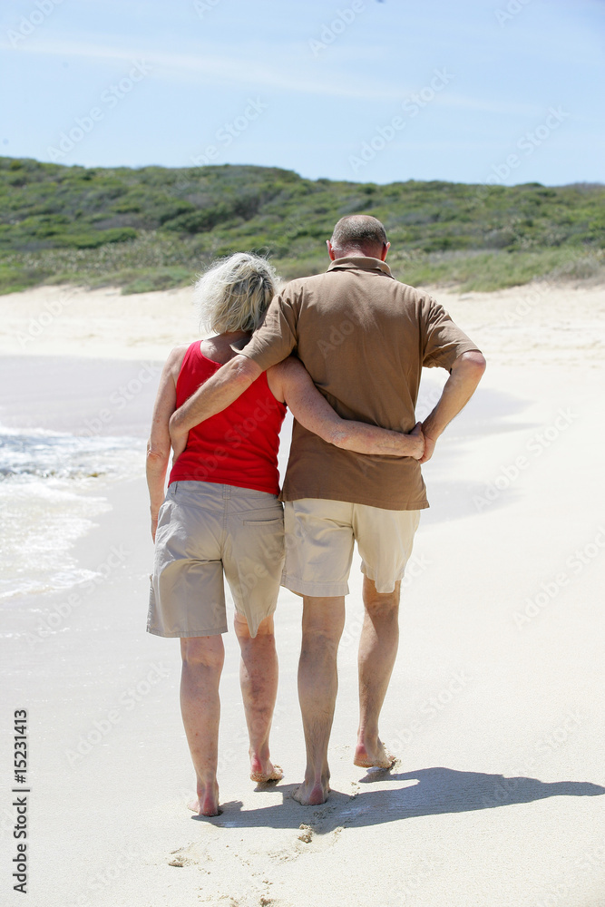 Couple de seniors marchant au bord de la plage
