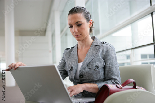 Femme d'affaires assise devant un ordinateur portable © auremar