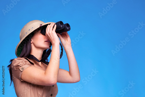 Woman in safari hat searching with binoculars