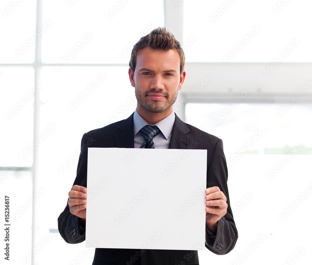 Serious businessman holding a white card Serious businessman holding a white card