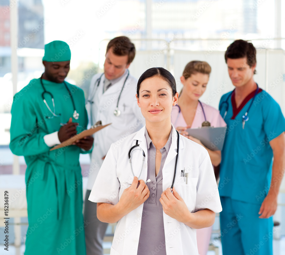 Beautiful doctor with her team in the background Beautiful doctor with her team in the background