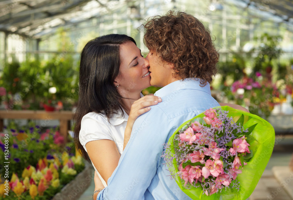 Naklejka premium couple kissing in flower nursery