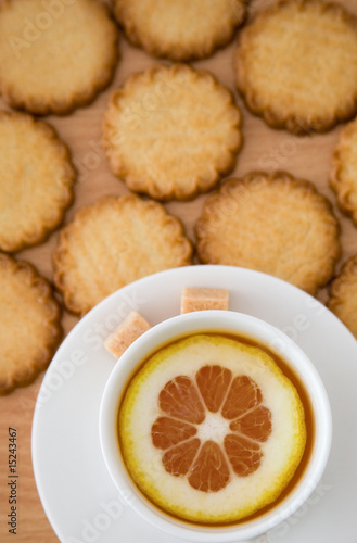 Cup of black tea with lemon  sugar and biscuits