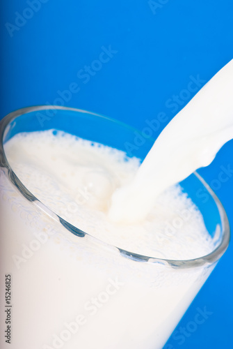 milk in glass on blue background