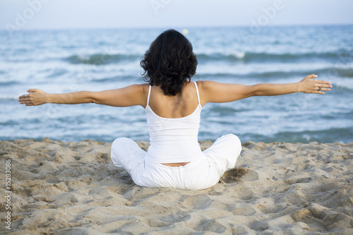 Woman making yoga exercise on the beach