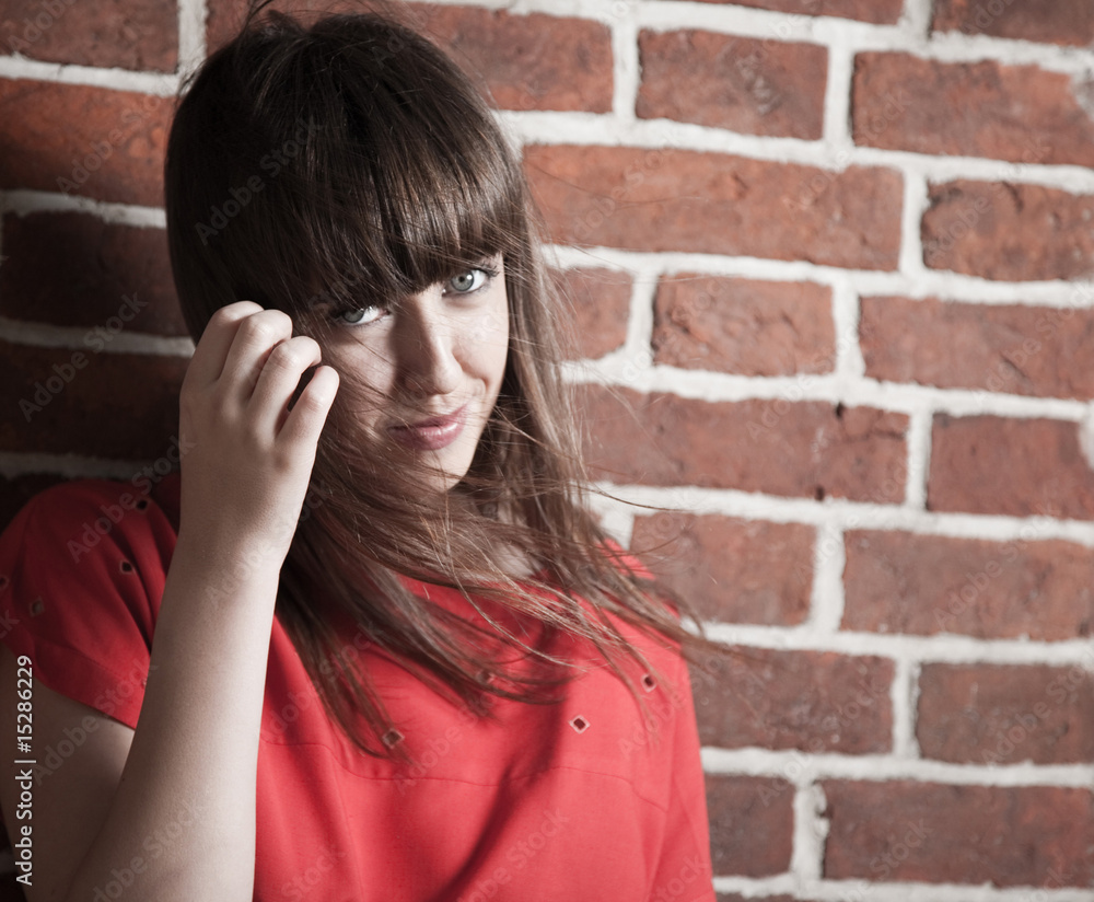 Beautiful brunette woman in front of a brick wall Beautiful brunette woman in front of a brick wall