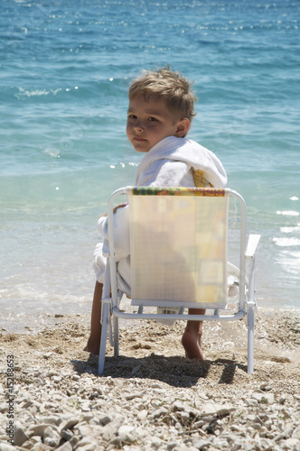 The boy sits in an armchair