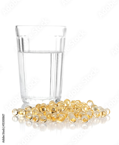 Glass with water and a heap of tablets, pills