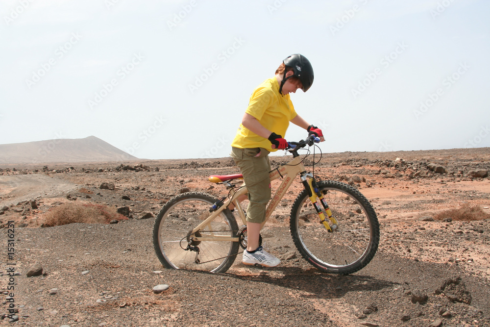 Kind mit Helm im Gelände auf Mountainbike Tour