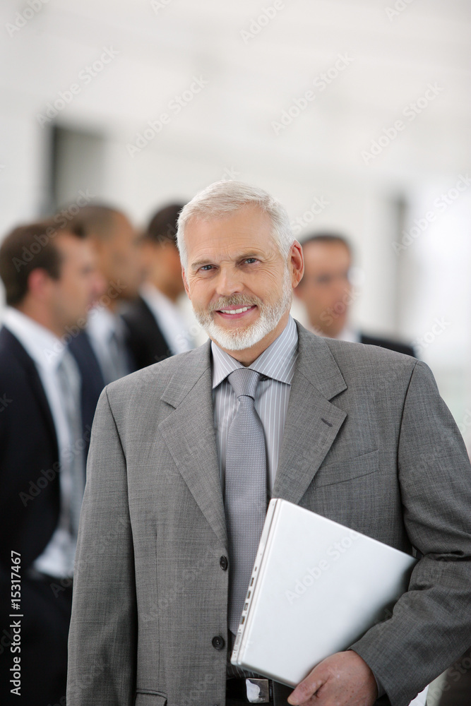 Homme d'affaires en costume avec un ordinateur portable fermé Homme d'affaires en costume avec un ordinateur portable fermé
