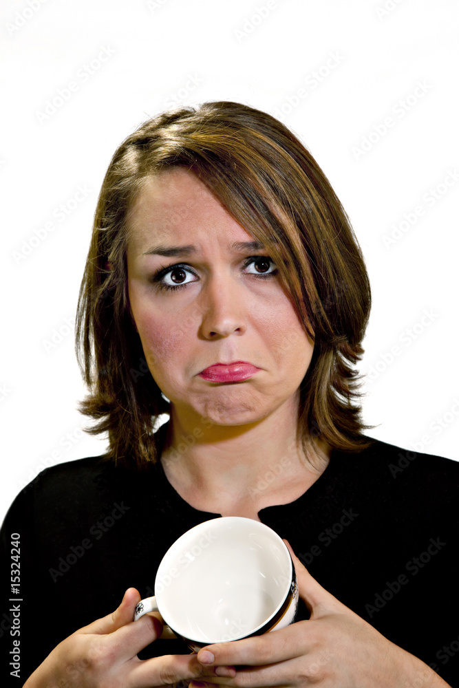 Beautiful brunette looking sad because coffee cup is empty Beautiful brunette looking sad because coffee cup is empty