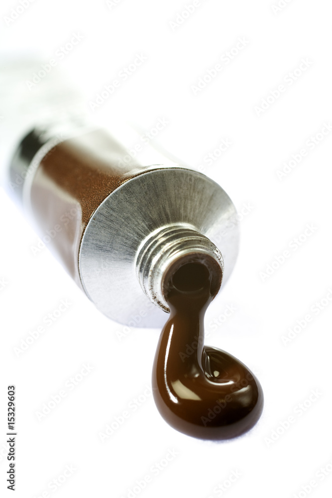 Brown paint coming from tube on white background Brown paint coming from tube on white background