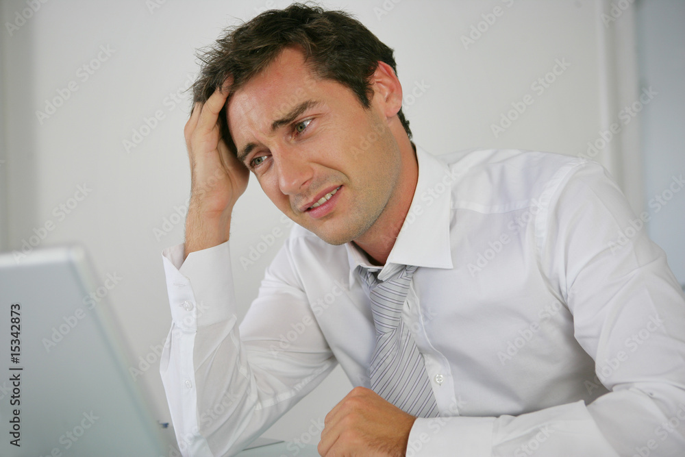 Naklejka premium Portrait d'un homme stressé devant un ordinateur portable
